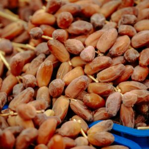 Pile of fresh, ripe dates in a blue crate from the Biskra region of Algeria.